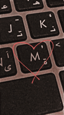 a close up of a keyboard with a heart drawn around the letter m