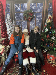 three children pose for a picture with santa