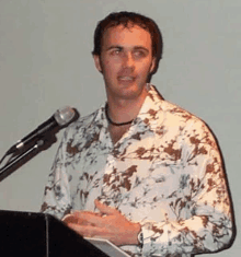 a man is standing at a podium in front of a microphone .