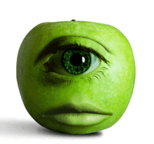 a green apple with a face carved into it