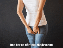 a woman holds her butt in front of a black background with hon har en darfink i roovveenn written below her