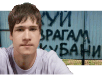 a man stands in front of a wall that has graffiti on it that says " купи врагам кубани "