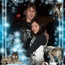 a man and a woman are posing for a picture with wolves and snowflakes in the background