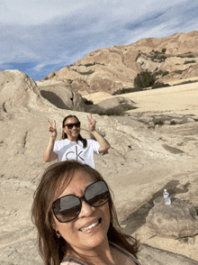 a woman wearing a calvin klein shirt is standing next to another woman wearing sunglasses