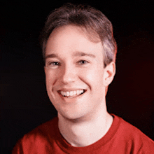 a young man in a red shirt is smiling for the camera