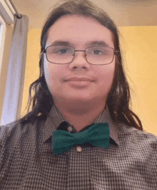 a young man with glasses and a green bow tie