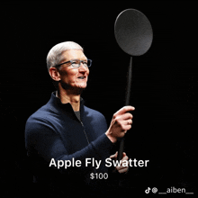 a man is holding an apple fly swatter in his hand