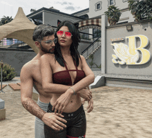 a man and a woman are hugging in front of a sign that says b