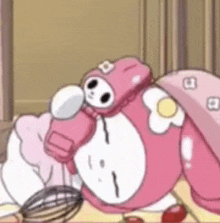 a cartoon character is laying on a table with a whisk and strawberries .