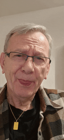 an older man wearing glasses and a plaid shirt