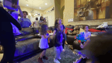 a group of children are dancing in a living room with a crocodile in the background