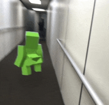 a blurred image of a green cube walking down a hallway