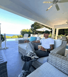 a man sitting on a couch with a cup of coffee in his hand