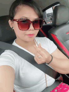 a woman wearing sunglasses is sitting in a car