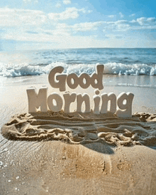 the words good morning are written in the sand on the beach