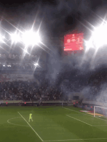 a soccer field at night with a scoreboard that says vodafone