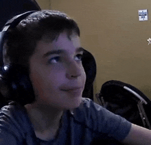 a young boy wearing headphones looks up at the camera