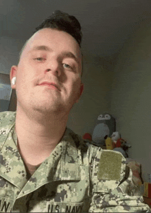 a man in a u.s. navy uniform is looking at the camera