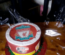 a liverpool football club cake is on a wooden table