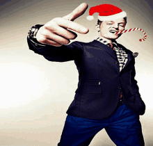 a man wearing a santa hat and holding a candy cane in his mouth