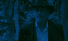 a man in a hat is talking to another man in a blue light