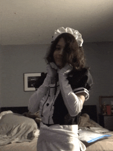 a woman in a maid costume is standing in a bedroom