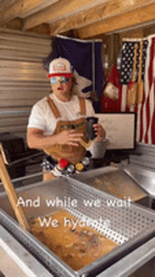 a man is standing in front of a tray of food with the words " and while we wait we hydrate " on the bottom