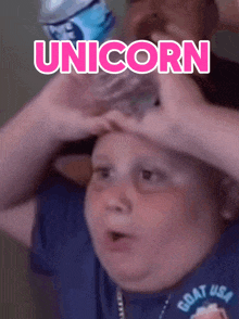 a boy holding a bottle of water on his head with the word unicorn written above him