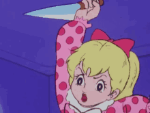 a girl in a pink polka dot dress is holding a knife in her right hand