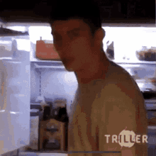 a man standing in front of an open refrigerator with triller written on the bottom