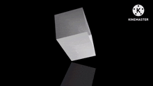 a white cube is floating in the air on a black background with a reflection of it .