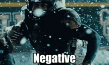 a football player is running in the snow and the word negative is displayed