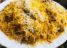 a close up of a plate of rice with chicken and cheese