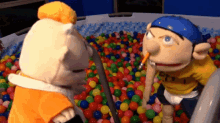 two stuffed animals are playing in a ball pit with one wearing a shirt that says pt