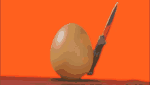 a balloon with a knife sticking out of it against an orange background