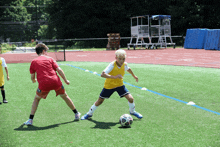 a boy in a yellow jersey is playing soccer