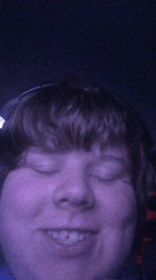 a close up of a person 's face with headphones on and their eyes closed