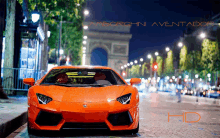 an orange lamborghini aventador is parked on the side of the road at night