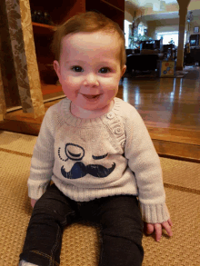 baby wearing a sweater with a mustache on it