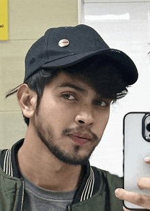 a young man taking a picture of himself with a hat on