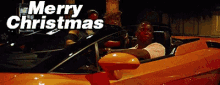 a man is driving a sports car with the words merry christmas written above him