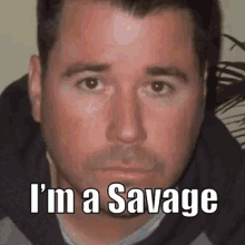 a close up of a man 's face with the words `` i 'm a savage '' on it .