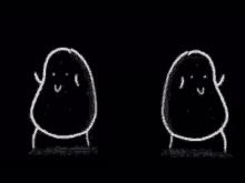 two potatoes are standing next to each other in the dark .