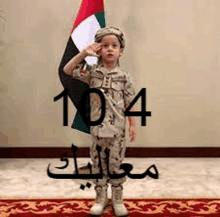 a young boy in a military uniform salutes while holding a flag .