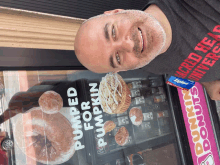 a man standing in front of a dunkin donuts display