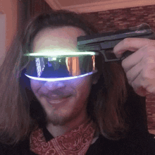 a man wearing futuristic goggles holds a gun