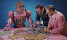 two men in pink suits looking at a pink robot