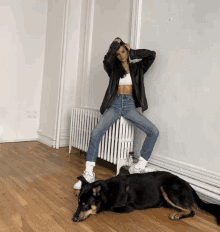 a woman sits on a radiator next to a dog