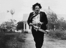 a man in a suit is holding a chainsaw in a black and white photo by creepyholics