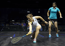 two women are playing squash on a court with an ad for pepsi behind them